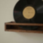 Vinyl record displayed upright on a wooden shelf