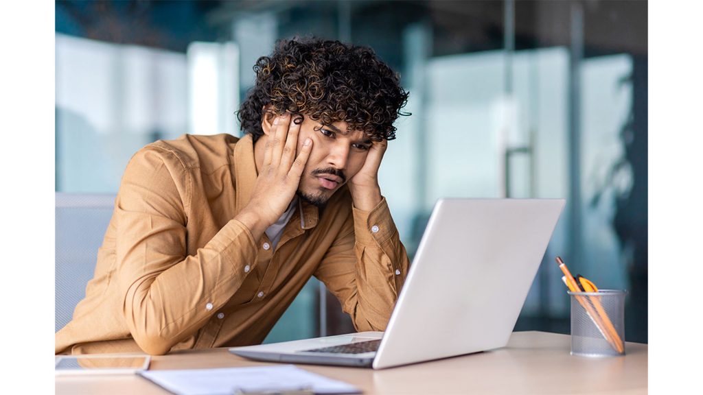 verzweifelter Mann mit Laptop