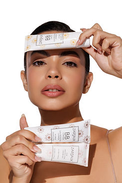 Woman with luminous Swiss skin holding a Sandine Zartaux serum bottle.