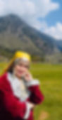 Image of Havovi posing and wearing a traditional Kashmiri dress and the backdrop is the mountains of Kashmir