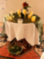 an altar with battery candles, a raven, and a bowl of water with fresh flowers