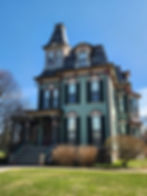A Second Empire house painted green with maroon accents. It was built in 1875.