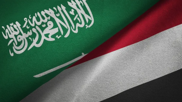 Close-up of Saudi and Yemen flags overlapping, green with Arabic script beside red, white, and black stripes.