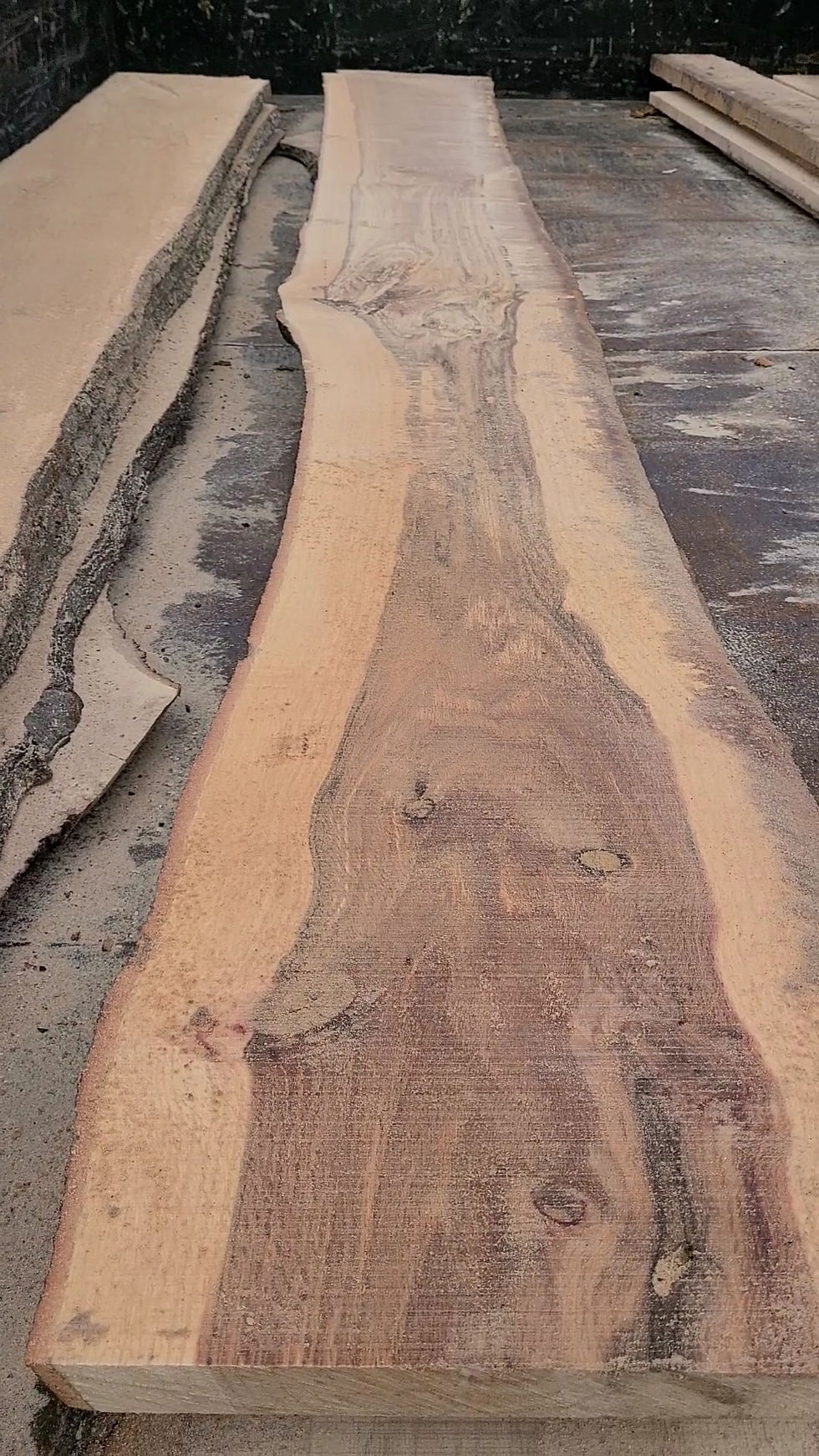 Laurel Oak in lumber form with light colored sap and dark colored pitch laying on the back of a dump truck with other stacks of lumber