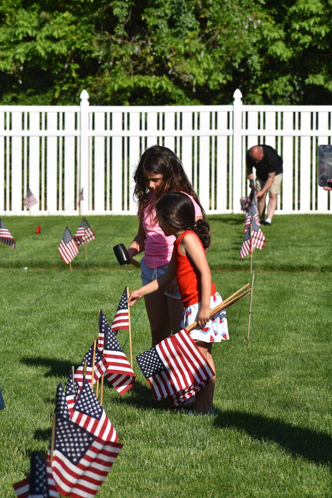 Teamwork makes the dream work; children worked together to evenly distribute the American flags throughout the yard.