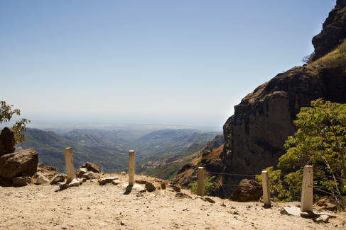 a view overlooking a vast landscape of valleys and hills all the way to the horizon. 