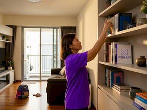 Homeowner arranging built-in living room shelving