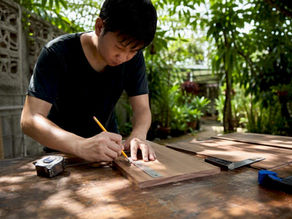 Carpenter measuring wood panel in studio