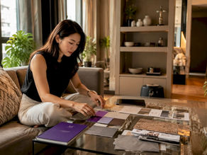Singapore apartment living room with neutral tones and woman arranging fabric swatches