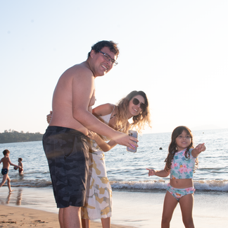 casal e filha se divertindo na praia