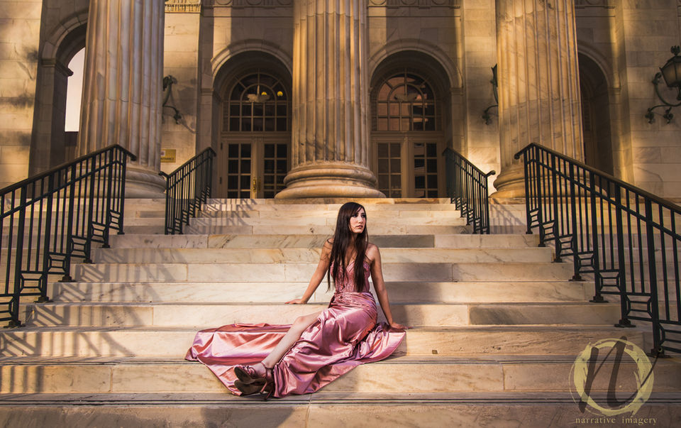 Female sitting on stairs of downtown denver building in prom dress
