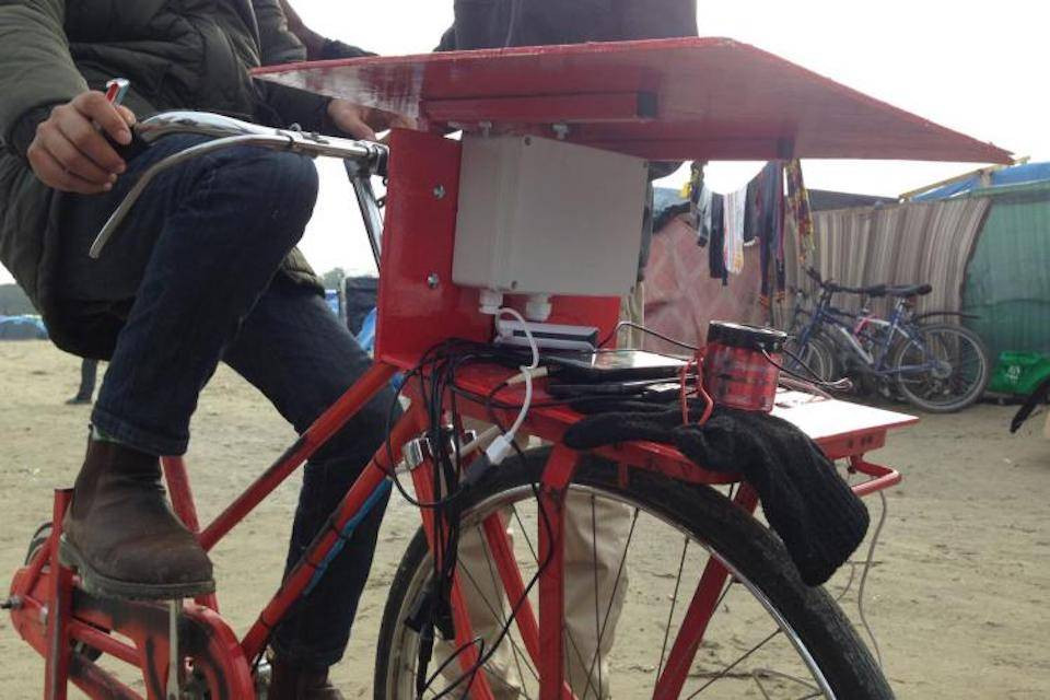 person on red bike charging mobile phone devices