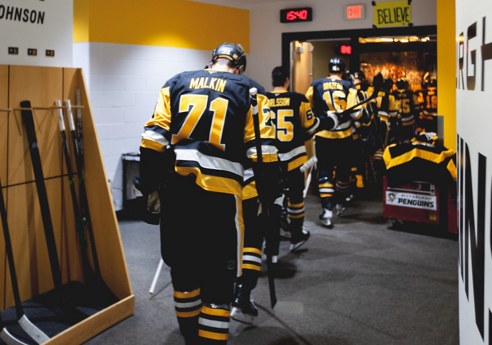 The Pittsburgh Penguins walking out to the ice under a "Belief" sign