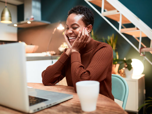 Person smiling at a laptop