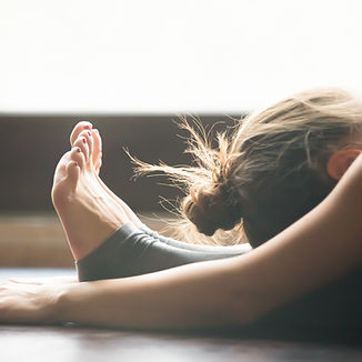 Pilates student stretching her legs.