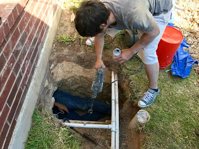 the plumbinator team working together to replacing piping under a house