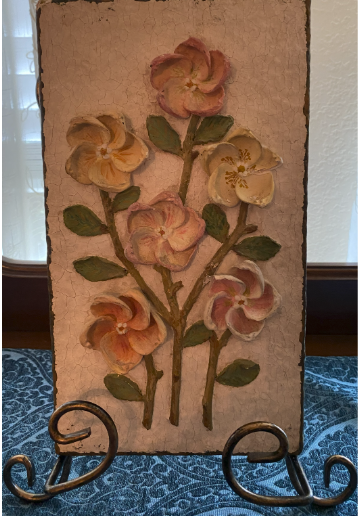art on a stand of pansies on a table in front of a window