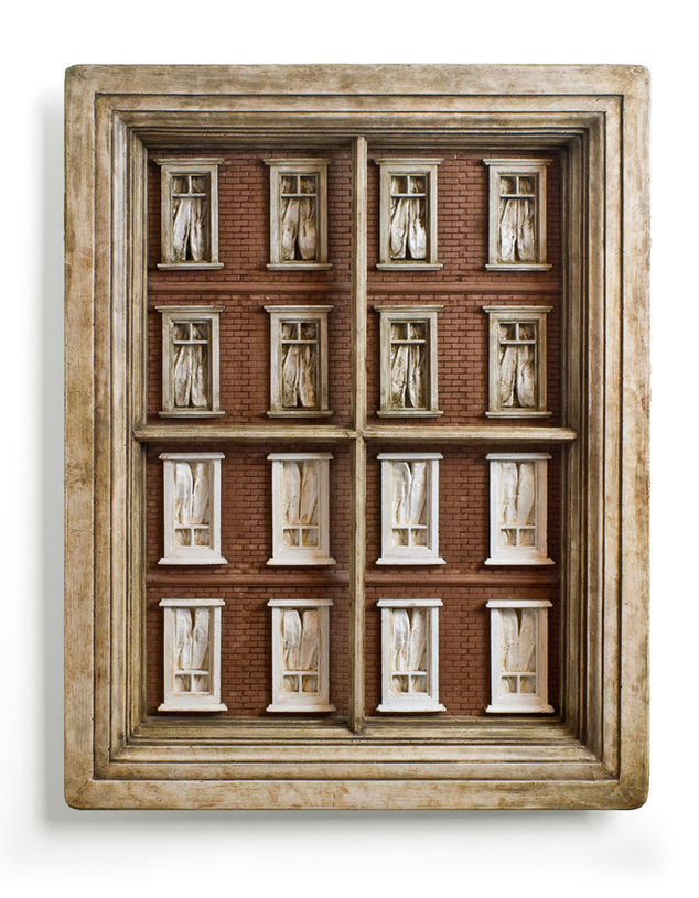Intricate building facade sculptures in a wooden frame