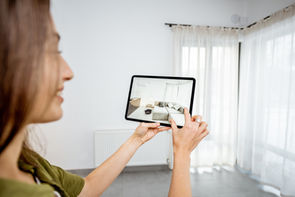 Woman using AR on a tablet to view a new sofa suite