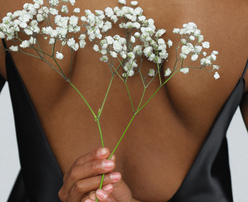 Woman holding flowers behind back