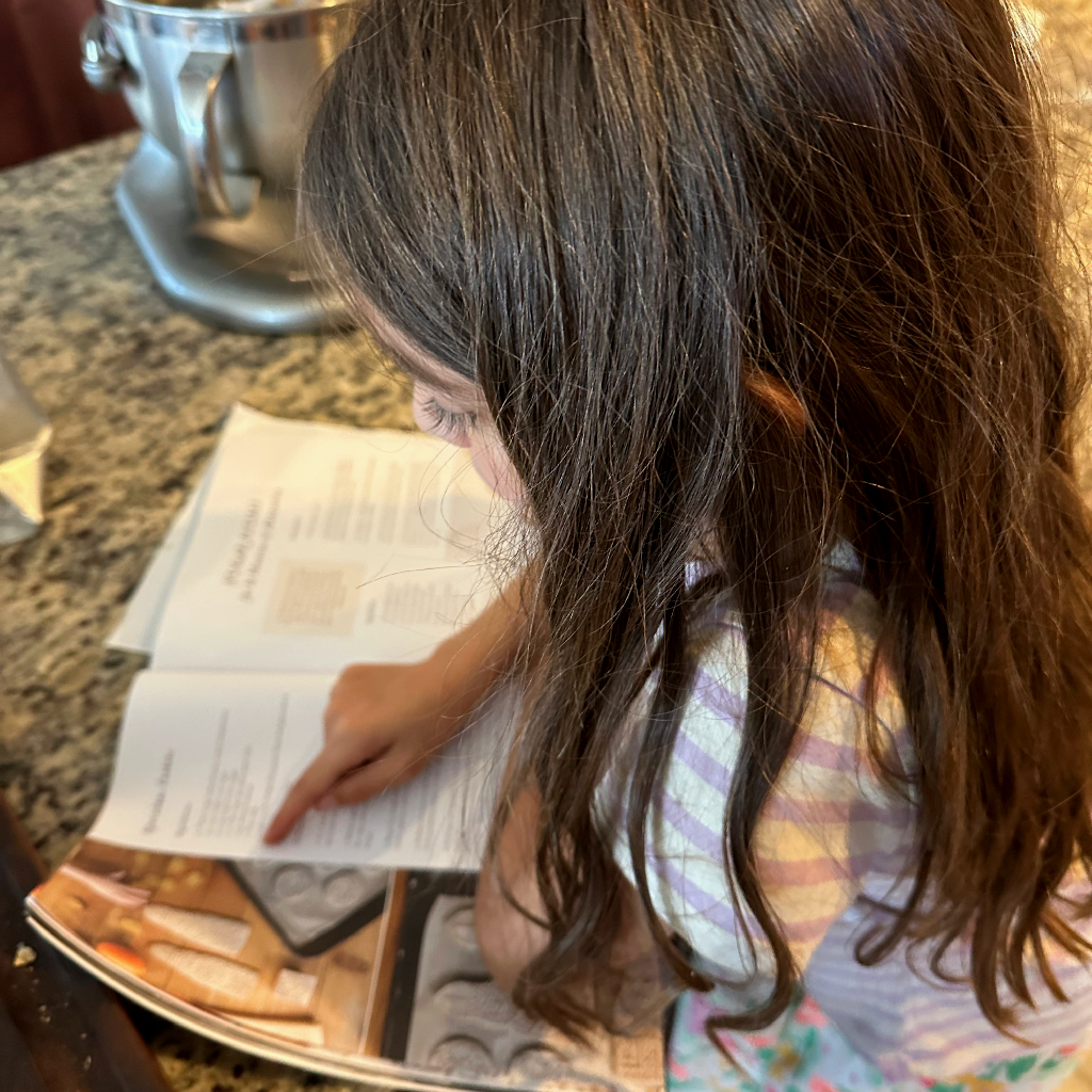girl reading recipe in kitchen. 
