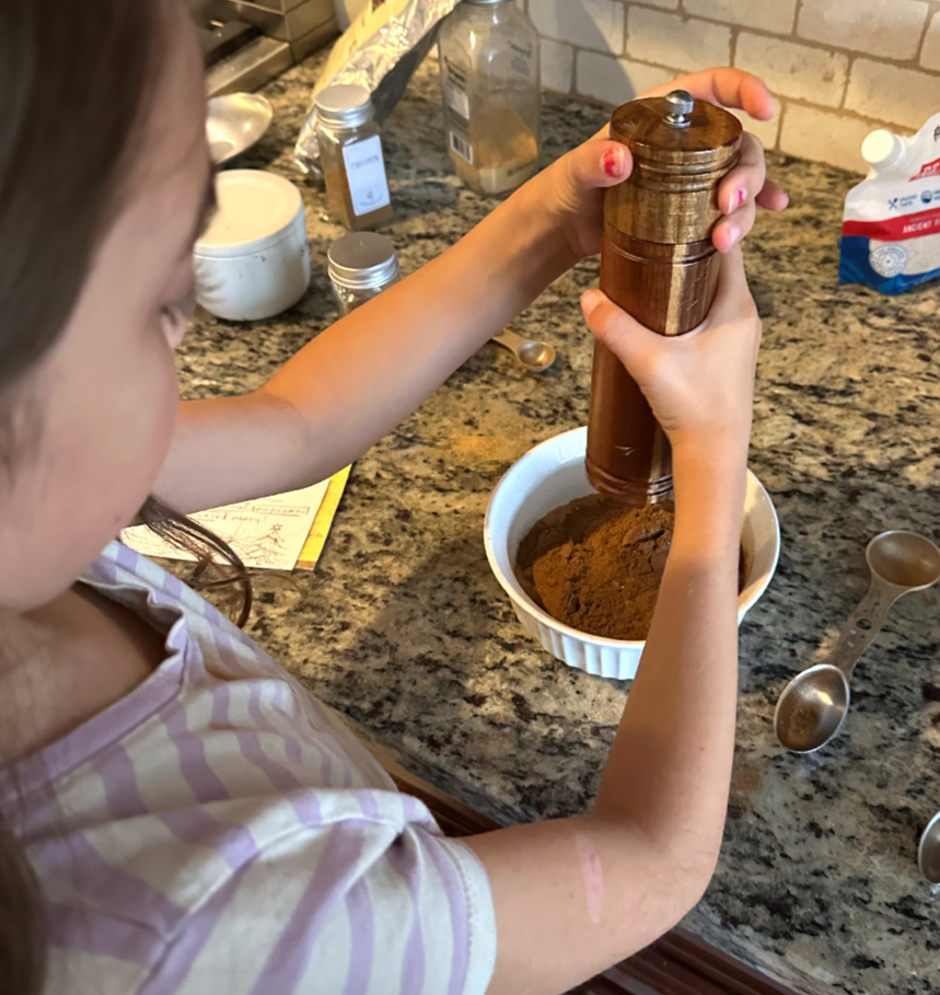 Girl griding pepper, speculaas cookie recipe. 