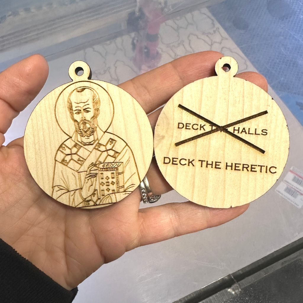 Wooden Christmas Ornament St. Nicholas, walnut and laser engraved in a man's hand, deck the halls, deck the heretic. 