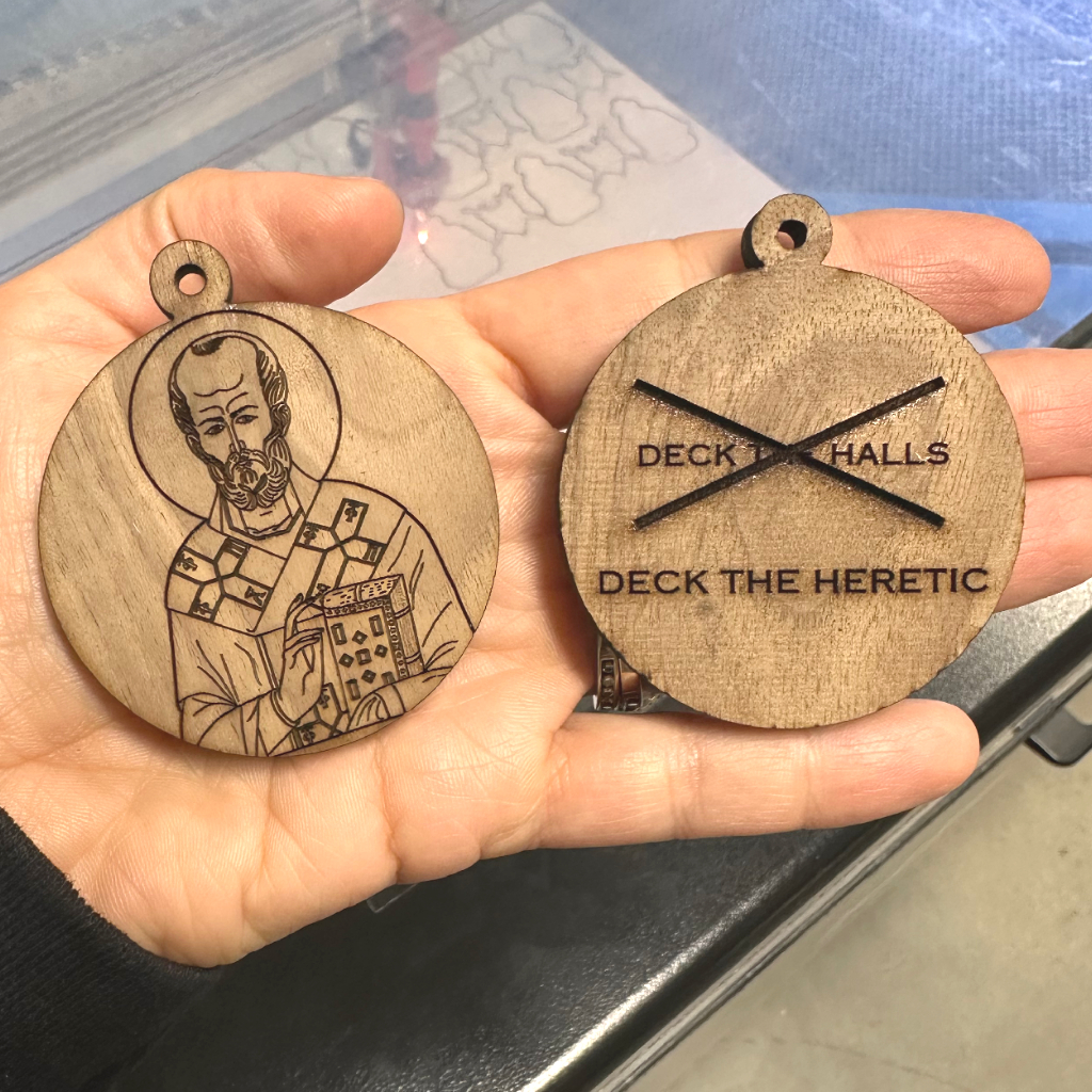 Wooden Christmas Ornament St. Nicholas, walnut and laser engraved in a man's hand, deck the halls, deck the heretic. 