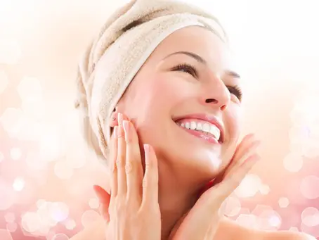 Portrait of the smiled women with a towel on her head ob bright pink and white background