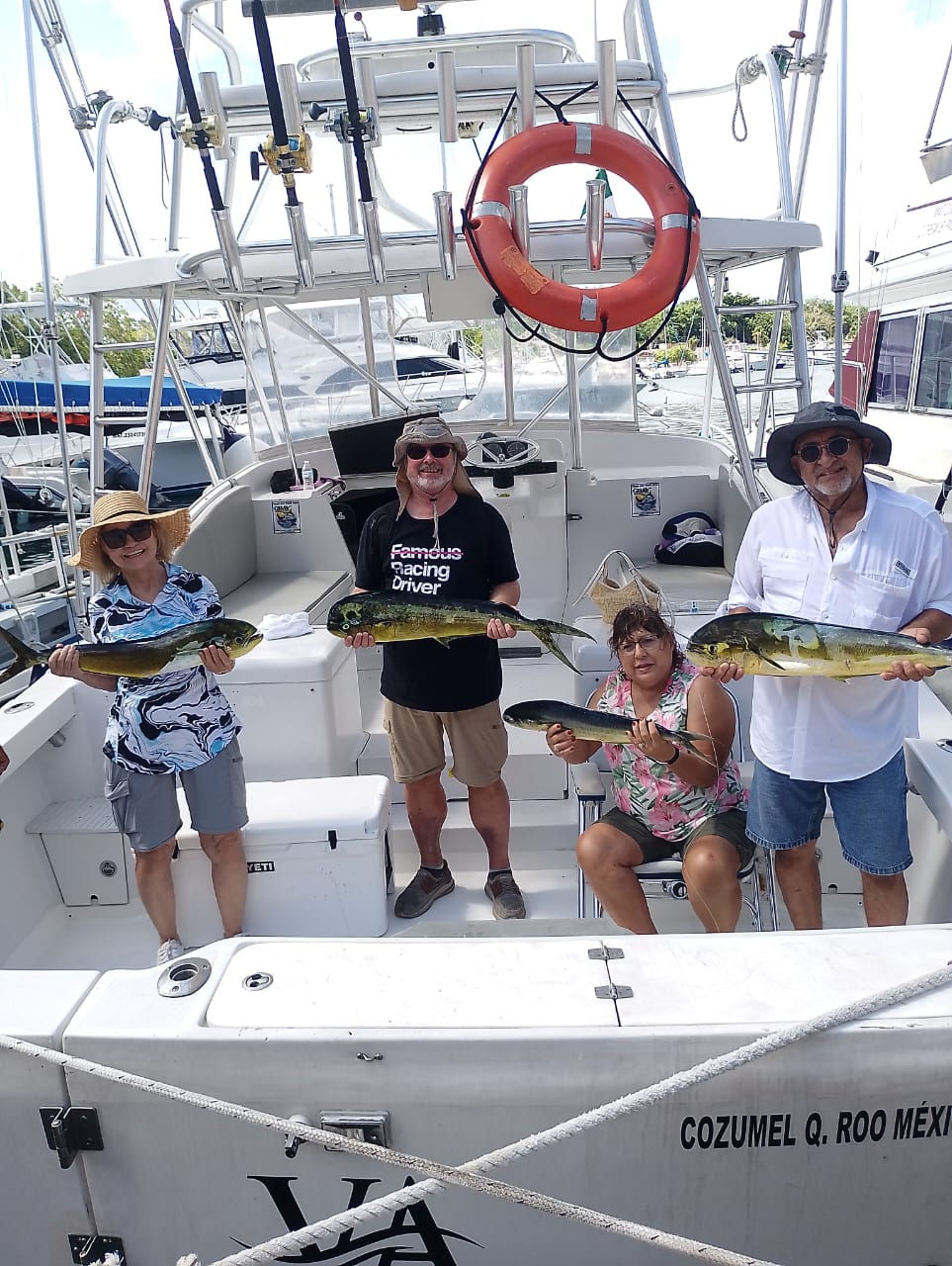 Anglers holding mahi-mahi after a Cozumel fishing charter