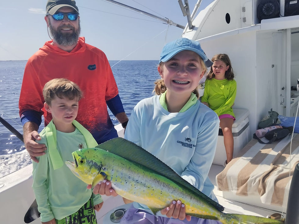 Family celebrating a freshly caught mahi-mahi during a deep sea fishing charter in Cozumel.