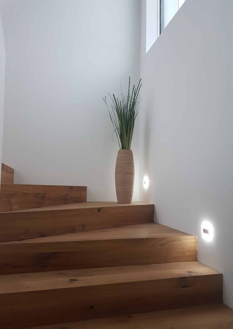 stiegenaufgang mit treppen aus holz und beleuchtung