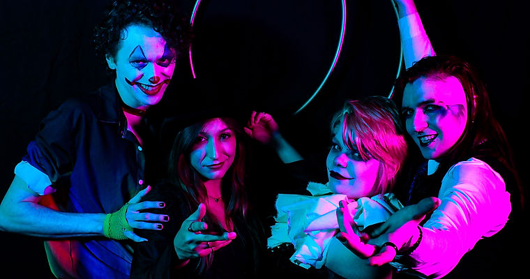 The Ringmaster, Magician, and two clowns inviting the audience in while holding the rings