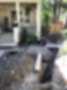 A construction site in front of a house with a hole dug by porch stairs