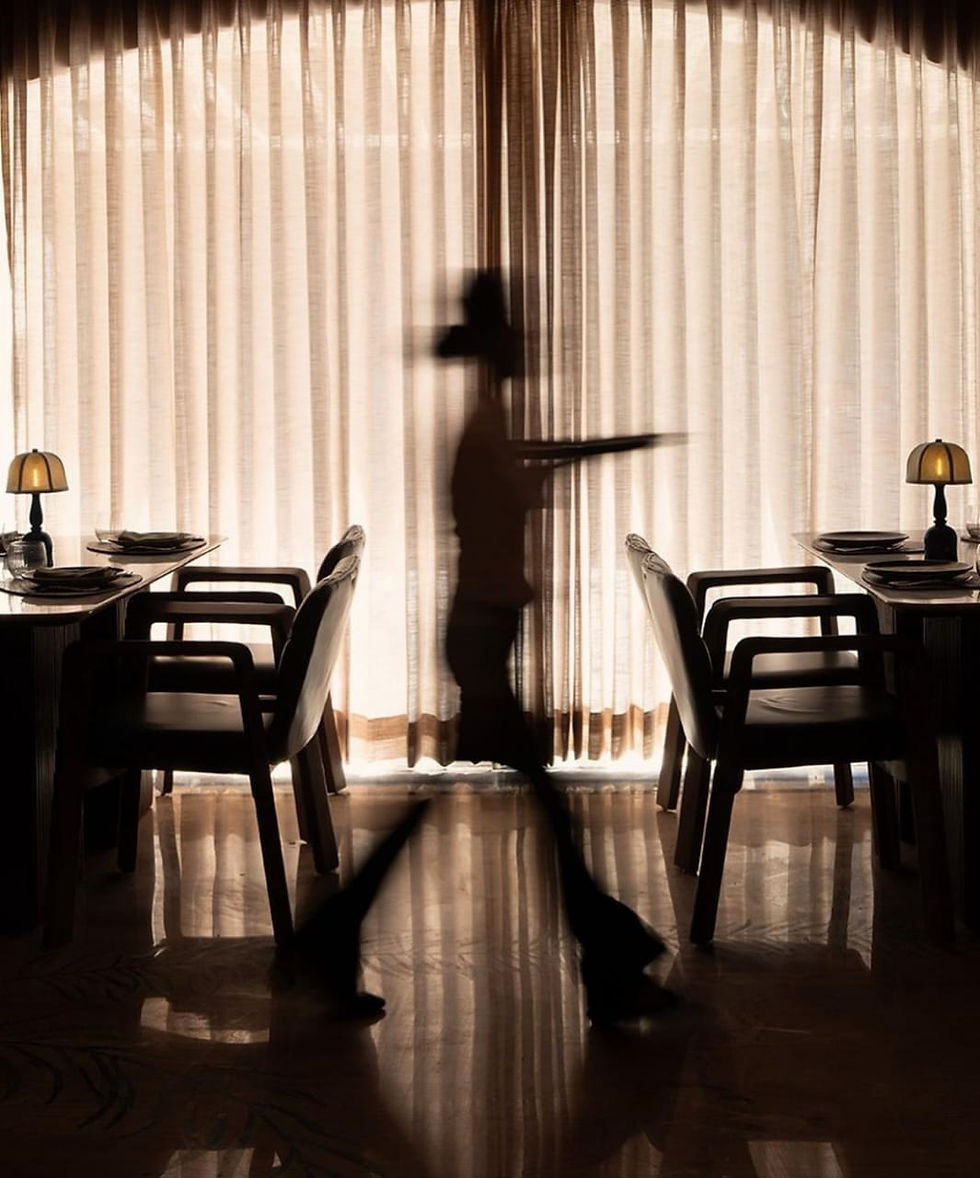 Step in, and it's like a warm hug from a fancy aunt. Wine-red walls and ceilings pop with gold touches, while cane lamps spill soft yellow glow everywhere. Wood tables mix with forest green chairs, keeping things chill and open. Ornate lamps overhead add that subtle sparkle without going overboard. At 7,000 sq ft, it feels roomy yet intimate, perfect for lingering chats. No loud chaos here; just elegant calm that pulls you into the illusion.