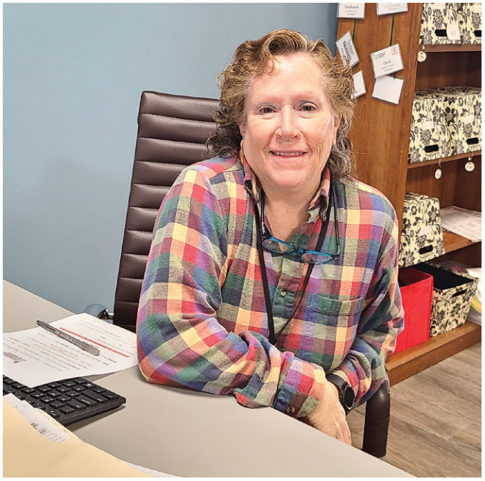 Social Services volunteer Kathryn Eckert seated at her desk at Interfaith Emergency Services.