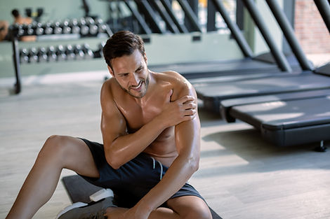 joven-atleta-sosteniendo-su-hombro-con-dolor-despues-del-entrenamiento-deportivo-en-un-gim