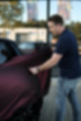 Illustratie Auto Wrappen Tilburg: Car Wrapping door een medewerker van Eviate Wraps. De medewerker brengt matte bordeaux-rode vinyl wrap aan op een 2018 F56 Mini Cooper - illustratie van car wrap dienst
