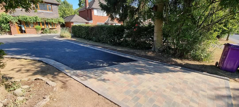 Black tarmac driveway finished with a brindle block paving apron
