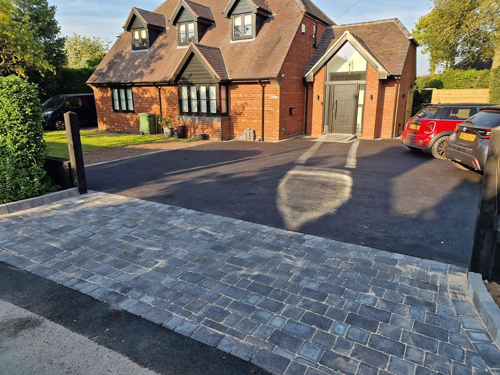 Black tarmac driveway with a charcoal block paving apron at the entrance