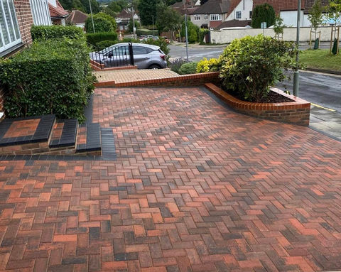 Red herringbone block paving driveway.