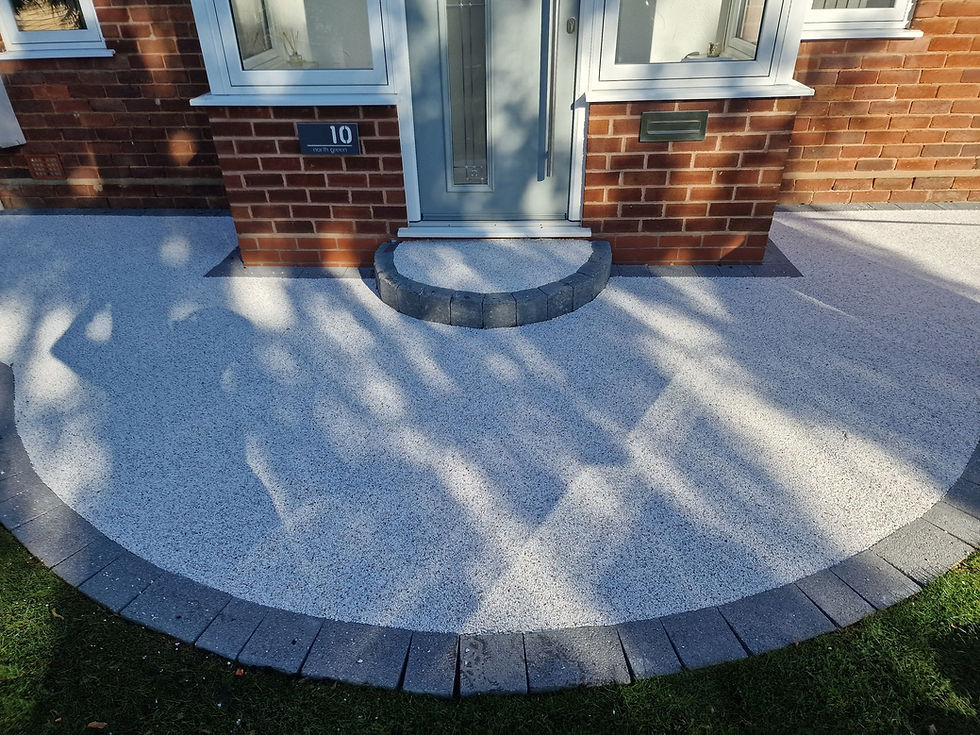 Silver grey resin bound path with a curved charcoal border at a front door