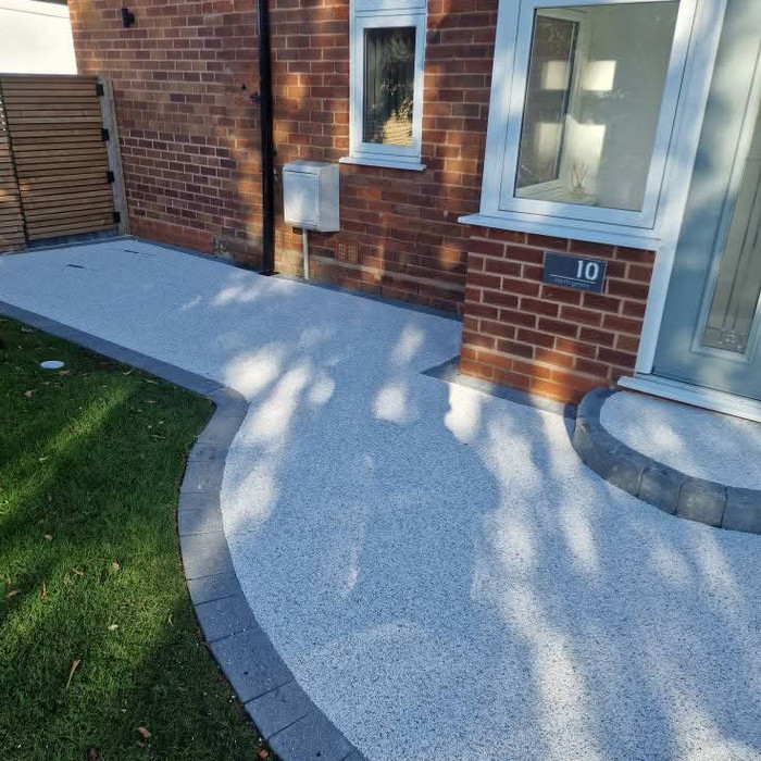 White resin bound curved garden path to front door