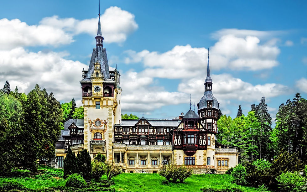 Wide angle view of Peles Castle surrounded by forest and mountains