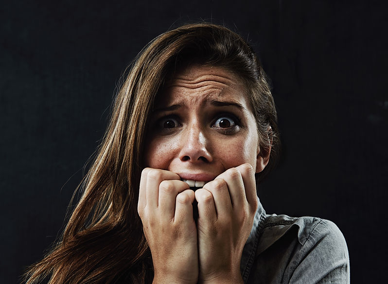 portrait-mental-health-woman-biting-nails-studio-black-background-reaction-fear-panic-face