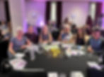 Five people smiling around a table at the Self-Management awards ceremony.