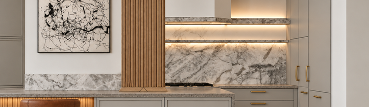 Front view of Gramercy Park kitchen with matte European cabinetry, fluted wood column, Calacatta Manhattan marble backsplash, brass hardware, and layered accent lighting.