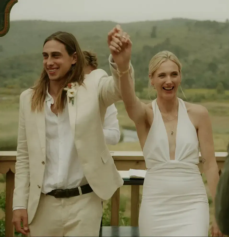 Bride and Groom Walking down the aisle after getting married hands in the air.webp