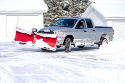 silver truck moving snow on a winter's day_edited