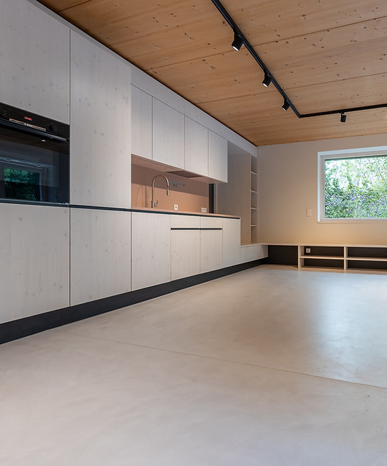 Cuisine moderne en bois clair, plafond en bois, grande fenêtre
